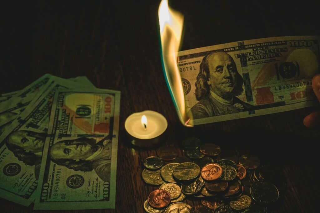 money being burnt with a candle
