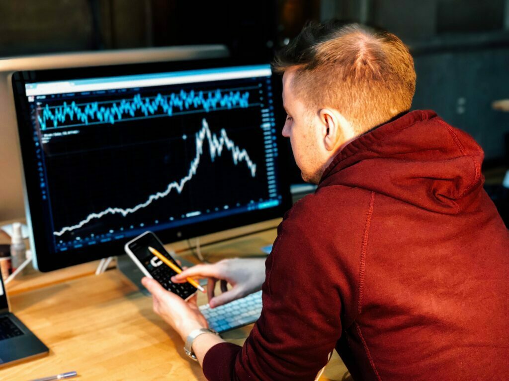 Man holding phone while looking at statistics