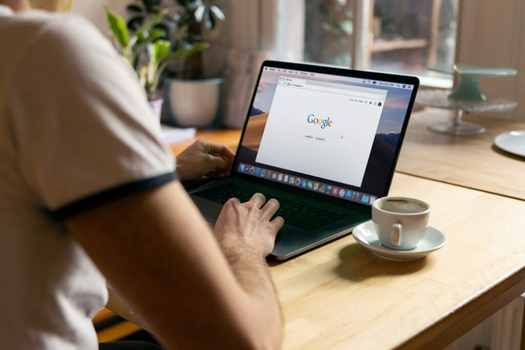 Person using Google to check for penalties on MacBook