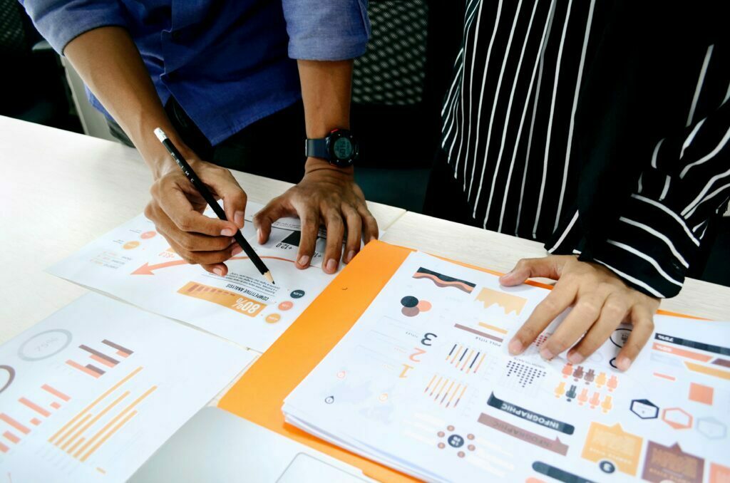 Person writing on paper with marketing statistics and data