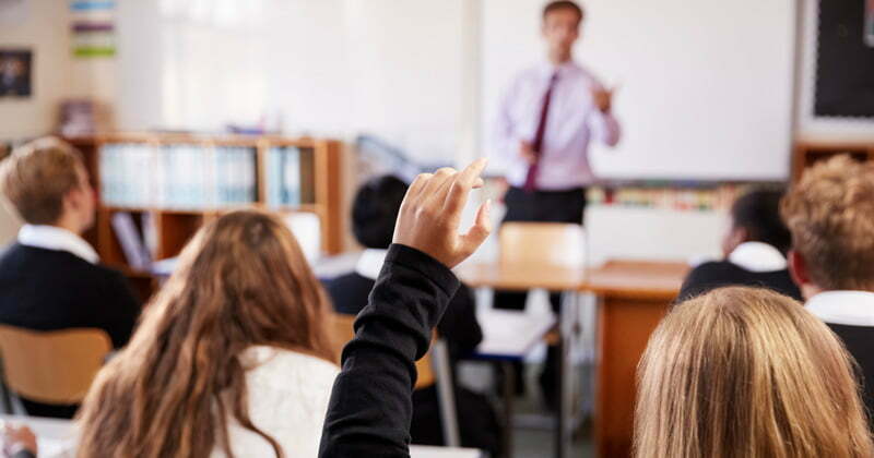 Child raising hand in classroom