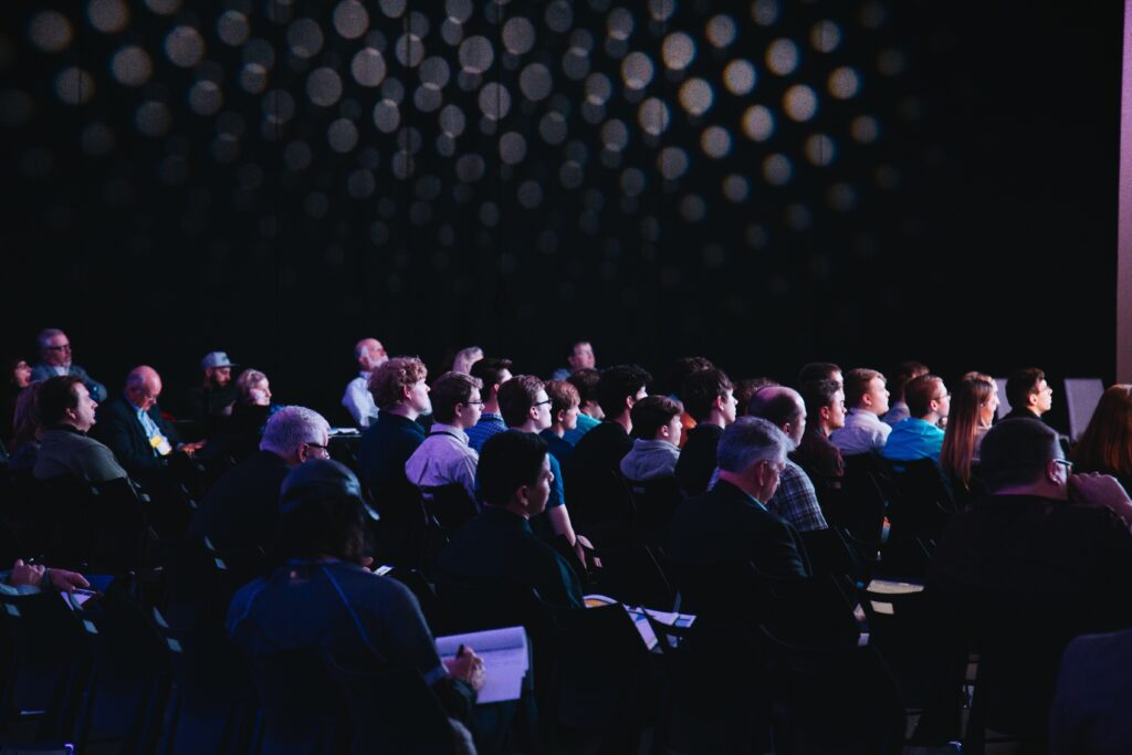 Crowd of people sitting and listening to a presentation