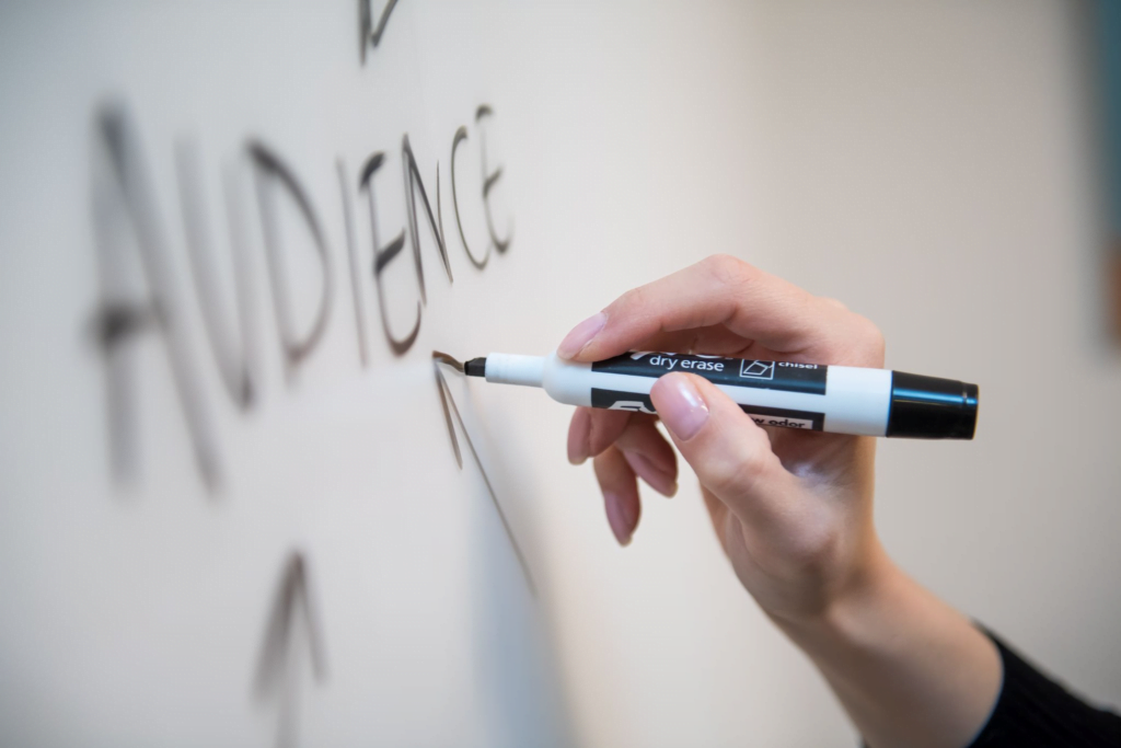 Whiteboard with the word audience on it written with a black marker